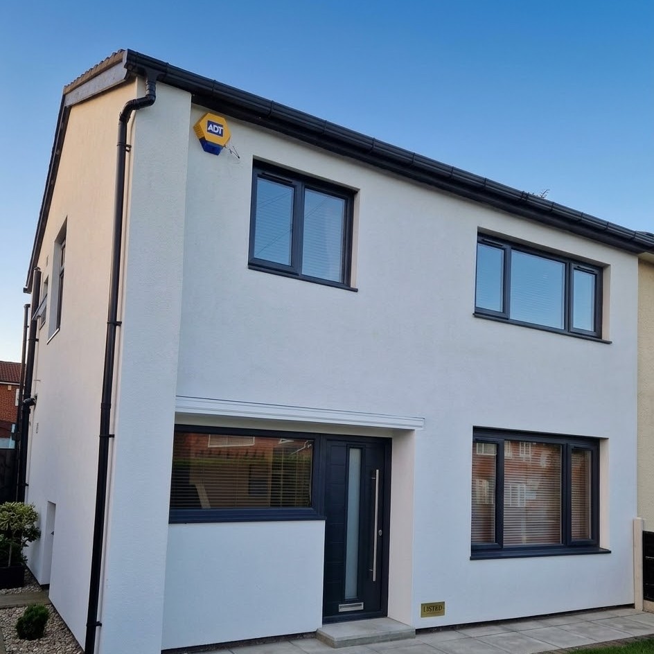 Full house installation of anthracite grey uPVC double glazing windows and front door on a white rendered property.